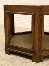 Load image into Gallery viewer, A close-up of a dark brown wooden end table with a rustic finish, featuring a lower shelf and a light-colored woven rug underneath.
