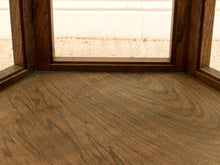 Load image into Gallery viewer, Close-up of a medium brown wood grain surface, likely a tabletop or shelf, with matching wooden frame elements and a softly blurred light background visible through a window or opening.
