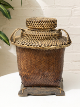 Load image into Gallery viewer, Vintage Southeast Asian woven basket with warm brown fiber body, intricate patterned lid, and raised round woven handle
