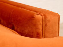 Load image into Gallery viewer, Close-up of a plush orange velvet sofa cushion with tufted channel stitching, showing the rich fabric texture and warm rust-orange color.
