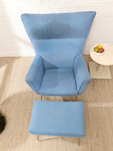 Load image into Gallery viewer, Vintage blue upholstered high-back lounge chair with angular padded arms, slender metal legs, and matching ottoman
