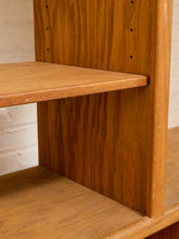 Load image into Gallery viewer, Close-up of a warm medium-brown wooden shelving unit with a visible wood grain finish and pre-drilled peg holes on the back panel.

