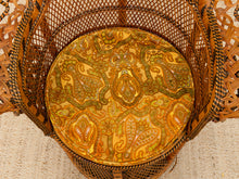 Load image into Gallery viewer, A round decorative tray with an intricate paisley pattern in gold, orange, and green, displayed inside a woven rattan basket.
