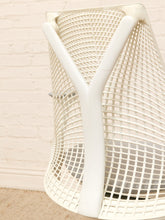 Load image into Gallery viewer, A close-up of a white molded plastic mesh chair backrest, showing the grid pattern and Y-shaped support structure, set against a light brick wall background.
