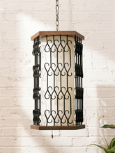 Load image into Gallery viewer, Vintage hanging pendant lantern with black wrought iron scrollwork, warm wood top and base, central diffused shade, and metal hanging chain
