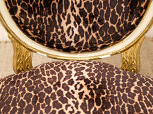 Load image into Gallery viewer, Close-up of an upholstered chair with leopard-print fabric and ornate gold metal legs and trim.
