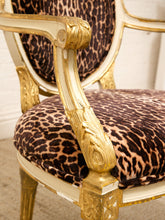 Load image into Gallery viewer, A close-up of an ornate vintage-style armchair featuring leopard-print velvet upholstery and a gilded gold frame.
