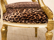 Load image into Gallery viewer, Close-up of an ornate chair seat upholstered in leopard-print velvet with a gilded gold frame and carved arms.
