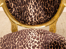 Load image into Gallery viewer, Close-up of an upholstered chair with a leopard print fabric and ornate gold frame details.
