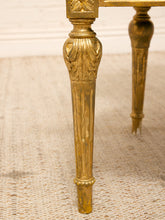 Load image into Gallery viewer, Close-up of an ornate gold table leg with carved detailing, standing on a textured beige rug.
