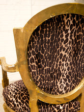 Load image into Gallery viewer, A close-up of an ornate chair featuring a gold gilded frame and leopard-print upholstery in brown, black, and beige.
