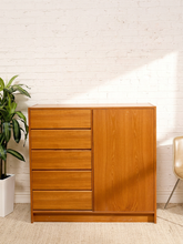 Load image into Gallery viewer, Danish modern wood cabinet dresser with five stacked drawers, one full-height cabinet door, and warm streamlined wood finish
