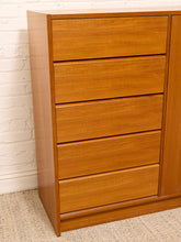 Load image into Gallery viewer, A mid-century modern wooden chest of drawers with a warm honey-toned finish, featuring four drawers and a cabinet door on the right, set against a white brick wall and beige carpet.
