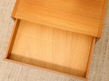 Load image into Gallery viewer, A close-up of a light oak wood drawer pulled open, showing the smooth wood grain interior, set against a neutral beige woven rug.
