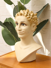 Load image into Gallery viewer, Vintage mannequin display head with stylized painted face, sculptural spiked hair, metallic gold finish, and neutral bust base
