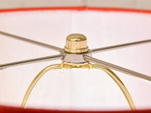 Load image into Gallery viewer, Close-up detail of a lampshade's metal frame and central cap, showing a gold-finished top cap and nut with silver-toned radial metal arms and a gold lower support ring against a white fabric shade.
