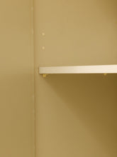 Load image into Gallery viewer, A close-up of a beige wall or cabinet interior with a white shelf mounted on the right side and two small fasteners visible on the left.
