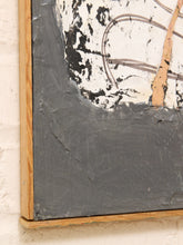 Load image into Gallery viewer, Close-up of a framed abstract painting with thick textured dark gray paint, black splatter details, a white upper section, and a light wood frame against a white brick wall.
