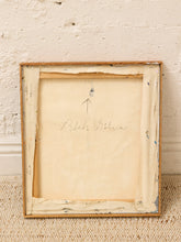 Load image into Gallery viewer, The back side of a vintage wooden picture frame leaning against a textured off-white brick wall on a woven rug. The cream-colored matting shows handwritten cursive writing and an arrow, with peeling paint showing hints of blue and brown.
