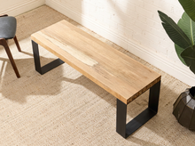 Load image into Gallery viewer, A modern industrial bench with a light natural wood top and black metal legs, placed on a beige textured rug in a bright room.
