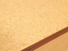 Load image into Gallery viewer, Close-up of a light natural wood surface with a prominent burl pattern and a darker brown wood edge visible along the bottom right.
