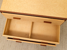 Load image into Gallery viewer, A close-up top-down view of a light natural wood drawer unit with one open drawer showing a divider, set on a textured beige carpet.
