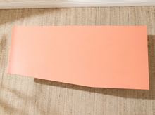 Load image into Gallery viewer, A solid peach-colored rectangular sheet of material, likely cardstock or craft paper, displayed diagonally on a textured beige woven rug.
