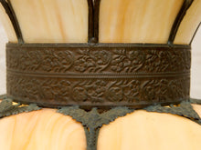 Load image into Gallery viewer, Close-up detail of a decorative lamp base featuring cream-colored stone or glass panels and a dark bronze ornate metal band with embossed floral scrollwork.
