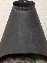 Load image into Gallery viewer, A dark charcoal gray metal chimney cap or hood protector with a textured, speckled finish, shown against a white painted brick wall.

