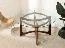 Load image into Gallery viewer, 1960s Adrian Pearsall attributed dining table with large round clear glass top and sculptural intersecting walnut-toned wood base
