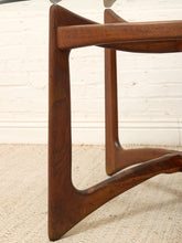 Load image into Gallery viewer, Close-up of a mid-century modern wooden table base with a rich walnut-like brown finish, set against a white brick wall and light beige textured carpet.
