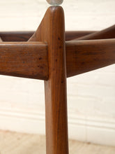 Load image into Gallery viewer, Close-up of a mid-century modern wooden chair showing the corner joint of the frame, with warm brown wood grain and a light cream wall background.
