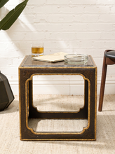 Load image into Gallery viewer, Vintage side table with textured black crackle-style top, antiqued gold edges, and open geometric base
