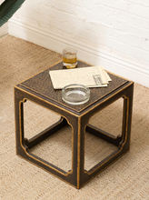 Load image into Gallery viewer, Vintage side table with textured black crackle-style top, antiqued gold edges, and open geometric base
