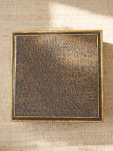Load image into Gallery viewer, A square decorative box with a dark brown and gold crackled faux-leather finish and a gold-trimmed border, photographed from above on a textured beige fabric background.
