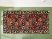 Load image into Gallery viewer, Vintage area rug with repeating rectangular geometric panels in brown, brick red, blue, teal, cream, olive, and coral tones
