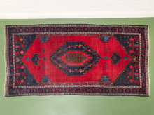 Load image into Gallery viewer, Vintage red area rug with central geometric medallion, navy and burgundy details, smaller geometric motifs, and layered patterned borders
