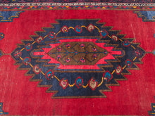 Load image into Gallery viewer, Vintage red area rug with central geometric medallion, navy and burgundy details, smaller geometric motifs, and layered patterned borders

