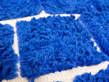 Load image into Gallery viewer, Close-up of a blue shaggy rug with a cream woven base and geometric pattern.
