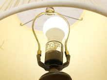 Load image into Gallery viewer, Close-up of a vintage-style table lamp shade and metal socket assembly with a glowing bulb, photographed from below inside the shade.
