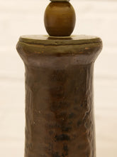 Load image into Gallery viewer, A close-up of a dark brown textured ceramic or stone vessel with a rounded top, shown against a light off-white background.
