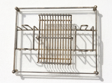 Load image into Gallery viewer, A vintage metal wire rack with a rectangular frame and a central grid basket, shown against a white textured background with distinct shadows.
