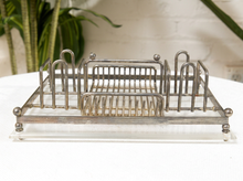 Load image into Gallery viewer, A vintage silver-tone metal organizer tray with a clear acrylic base, featuring multiple upright loops and a central basket-style compartment, displayed on a white surface.

