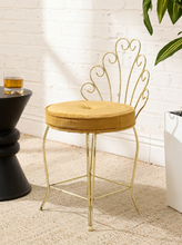 Load image into Gallery viewer, Vintage brass-tone vanity chair with ornate scrolling metal backrest, slender legs, and round button-tufted caramel brown upholstered seat
