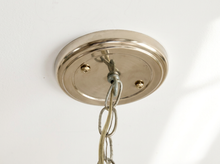 Load image into Gallery viewer, A close-up of a polished nickel ceiling canopy with a hanging chain, shown against a plain white wall.
