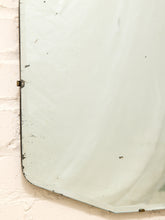 Load image into Gallery viewer, A vintage rectangular mirror with a distressed, weathered finish, mounted on a textured off-white brick wall.
