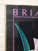 Load image into Gallery viewer, A close-up of a framed poster or print mounted on a textured off-white wall. The artwork has a black background with large pink lettering reading 'BRIA' and a stylized teal and pink abstract floral or ribbon-like graphic.
