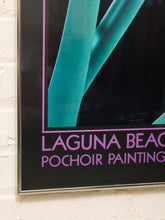 Load image into Gallery viewer, A framed poster featuring a teal and black abstract design with purple text reading 'LAGUNA BEACH POCHOIR PAINTING' mounted on a white brick wall.
