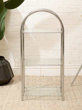 Load image into Gallery viewer, Vintage three-tier display shelf with polished chrome tubular frame, clear glass shelves, and tall rounded supports
