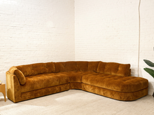 Load image into Gallery viewer, Prima curved sectional sofa in Thriller Amber with golden amber upholstery, deep button-tufted seats, channel-tufted back cushions, and rounded silhouette
